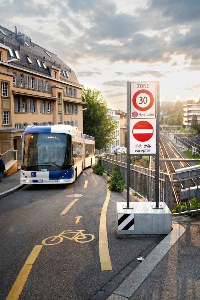Modern city bus on a street in Lausanne, Switzerland with cycling lane and road signs.